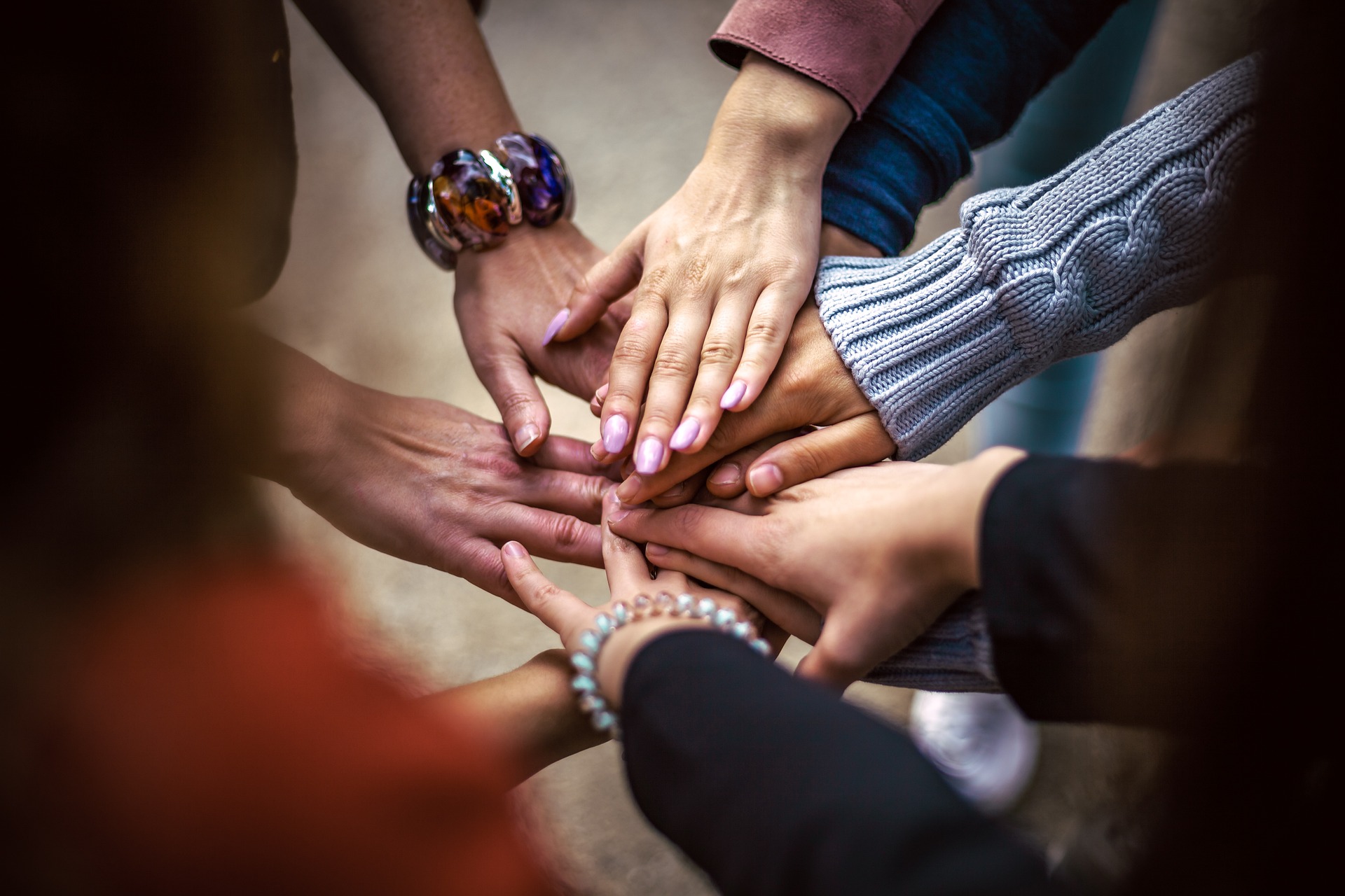 Personas dándose la mano Personas de diferentes etnias colocando sus manos una sobre la otra.